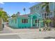 Charming turquoise home with a brick driveway and lush landscaping on a sunny day offering a tropical atmosphere at 106 23Rd Ave, St Pete Beach, FL 33706