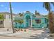 Charming turquoise home with front seating area, lush landscaping, and a brick driveway and tropical ambiance at 106 23Rd Ave, St Pete Beach, FL 33706