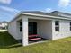 Back patio with a red picnic table and view of a well-manicured lawn at 11833 Clare Hill Ave, Riverview, FL 33579