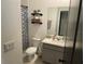 Stylish bathroom with a modern vanity, decorative shelves, and a patterned shower curtain at 11833 Clare Hill Ave, Riverview, FL 33579