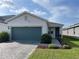 Attractive one-story home with a pristine lawn, brick paver driveway, and teal garage at 11833 Clare Hill Ave, Riverview, FL 33579