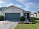Beautiful single-Gathering home with green grass, a brick paver driveway, and teal garage door at 11833 Clare Hill Ave, Riverview, FL 33579