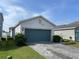 Lovely single-level home featuring a teal two-car garage and manicured lawn at 11833 Clare Hill Ave, Riverview, FL 33579