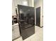 Modern black stainless refrigerator and gray cabinets in a well-lit kitchen with tile flooring at 11833 Clare Hill Ave, Riverview, FL 33579
