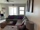 Cozy living room featuring an oversized sectional couch with accent pillows, ceiling fan, and bright natural light at 11833 Clare Hill Ave, Riverview, FL 33579