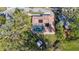 An aerial view shows the home's tile roof, backyard and screened pool with lush landscaping at 1201 Kapok Kove Cir, Clearwater, FL 33759