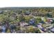 An aerial view of a residential area with mature trees and the water in the distance, conveying serenity at 1201 Kapok Kove Cir, Clearwater, FL 33759