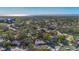 Wide aerial shot showcases the residential neighborhood surrounded by trees and the bay in the background at 1201 Kapok Kove Cir, Clearwater, FL 33759
