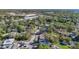 Expansive aerial view of a neighborhood with lush greenery, and view to the distant ocean at 1201 Kapok Kove Cir, Clearwater, FL 33759