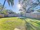 A lush green backyard is fully fenced, offering privacy and plenty of space for outdoor activities at 1201 Kapok Kove Cir, Clearwater, FL 33759