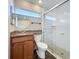 Bathroom featuring a vanity with granite counters, a framed mirror, a shower with glass doors and tiled pebble floor at 1201 Kapok Kove Cir, Clearwater, FL 33759