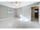 This bedroom has tile flooring, a ceiling fan, neutral paint and a window at 1201 Kapok Kove Cir, Clearwater, FL 33759