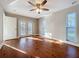 Bedroom with hard wood floors, ceiling fan, and french door access to the backyard at 1201 Kapok Kove Cir, Clearwater, FL 33759