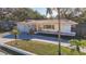 A single-story home with a yellow exterior and a well-manicured lawn, showcasing a welcoming facade at 1201 Kapok Kove Cir, Clearwater, FL 33759