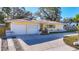 A well-maintained one-story home featuring a two-car garage, a tile roof and a wide driveway at 1201 Kapok Kove Cir, Clearwater, FL 33759