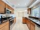 Modern kitchen featuring stainless steel appliances, granite counters, and tile flooring at 1201 Kapok Kove Cir, Clearwater, FL 33759