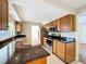 Well-lit kitchen features granite countertops, stainless steel appliances, and oak cabinetry at 1201 Kapok Kove Cir, Clearwater, FL 33759
