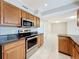 Updated kitchen with granite countertops, stainless steel appliances, and sleek tile floors at 1201 Kapok Kove Cir, Clearwater, FL 33759