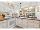 Well-lit kitchen featuring white appliances and cabinetry, with a view to the dining and living room at 12300 Vonn Rd # 2204, Largo, FL 33774