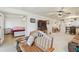 Bright living room featuring a wooden bench, ceiling fan, and entry to the main bedroom with hardwood floors at 12300 Vonn Rd # 2204, Largo, FL 33774
