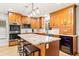 Well-equipped kitchen with stainless steel appliances, wooden cabinets, and a large island with seating at 12762 98Th St, Largo, FL 33773