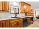 Close-up of the kitchen featuring wood cabinets, granite countertops, black appliances, and a stylish backsplash at 12762 98Th St, Largo, FL 33773