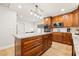 Bright kitchen featuring a large kitchen island with seating, wood cabinets, granite countertops, and modern appliances at 12762 98Th St, Largo, FL 33773