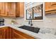 Kitchen detail showcasing granite countertops, sleek black sink and faucet, and a window overlooking the backyard at 12762 98Th St, Largo, FL 33773