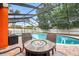 Relax and entertain in this backyard featuring a screened pool and cozy fire pit seating area at 12762 98Th St, Largo, FL 33773
