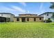 Expansive backyard with lush green lawn, complemented by the home's neutral exterior and dark trim at 14050 Arbor Pines Dr, Riverview, FL 33579