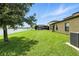 Backyard view featuring lush lawn, screened pool area, and a scenic lake beyond at 14050 Arbor Pines Dr, Riverview, FL 33579