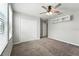 Bedroom with a ceiling fan, closet, floating shelving, and plush neutral-toned carpet at 14050 Arbor Pines Dr, Riverview, FL 33579