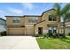 Charming two-story home featuring a two-car garage, landscaped yard, and welcoming front entrance at 14050 Arbor Pines Dr, Riverview, FL 33579
