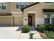 Front Entrance close up with a brown door and two-car garage at 14050 Arbor Pines Dr, Riverview, FL 33579