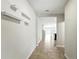 Long hallway with tile flooring, wall shelves and view into the home's open floor plan at 14050 Arbor Pines Dr, Riverview, FL 33579