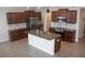 Gourmet kitchen featuring stainless steel appliances, dark wood cabinets, and a center island at 14050 Arbor Pines Dr, Riverview, FL 33579