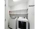Laundry room with modern washer and dryer, shelving, and white walls at 14050 Arbor Pines Dr, Riverview, FL 33579