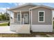 Charming single-story home with gray siding, white trim, and a welcoming front porch at 1423 Venetia St, Nokomis, FL 34275