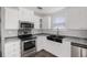 Modern kitchen with stainless steel appliances, farmhouse sink, and ample cabinet space at 1423 Venetia St, Nokomis, FL 34275