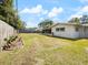 Large backyard showcasing mature landscaping, a privacy fence, and white home exterior at 1531 Picardy Cir, Clearwater, FL 33755