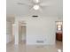 Spacious bedroom with ceiling fan, polished floors, and view of bathroom and closet at 1531 Picardy Cir, Clearwater, FL 33755