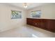 Cozy bedroom with paneled walls, ceiling fan, and two windows, offering a comfortable living space at 1531 Picardy Cir, Clearwater, FL 33755