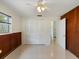 Bedroom featuring paneled accent walls, a ceiling fan, double-door closet, and neutral flooring at 1531 Picardy Cir, Clearwater, FL 33755