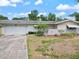 The house has a two-car garage and a well-manicured lawn at 1531 Picardy Cir, Clearwater, FL 33755