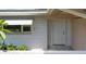 Front of a house with a white brick wall, and a white door at 1531 Picardy Cir, Clearwater, FL 33755