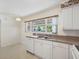 A kitchen with white cabinets, countertops, and a stainless steel sink at 1531 Picardy Cir, Clearwater, FL 33755