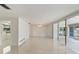 Bright living room featuring polished floors, fan, and sliding glass doors to enclosed patio at 1531 Picardy Cir, Clearwater, FL 33755