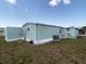 Exterior side view of the home with a bare yard and utility box at 1710 7Th Sw St # 24, Ruskin, FL 33570