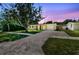 Exterior view of house with long driveway and green lawn at dusk at 1764 St Croix Dr, Clearwater, FL 33759