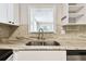 Kitchen close up featuring a stainless steel sink with granite countertop and backsplash at 1764 St Croix Dr, Clearwater, FL 33759